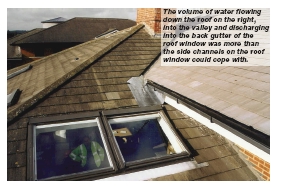 The volume of water flowing down the roof on the right, into the valley and discharging into the back gutter of the roof window was more than the side channels on the roof window could cope with.