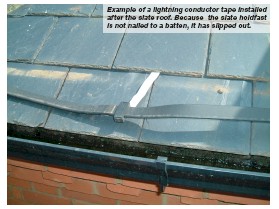 Example of a lightning conductor tape installed after the slate roof. Because the slate holdfast is not nailed to a batten, it has slipped out.